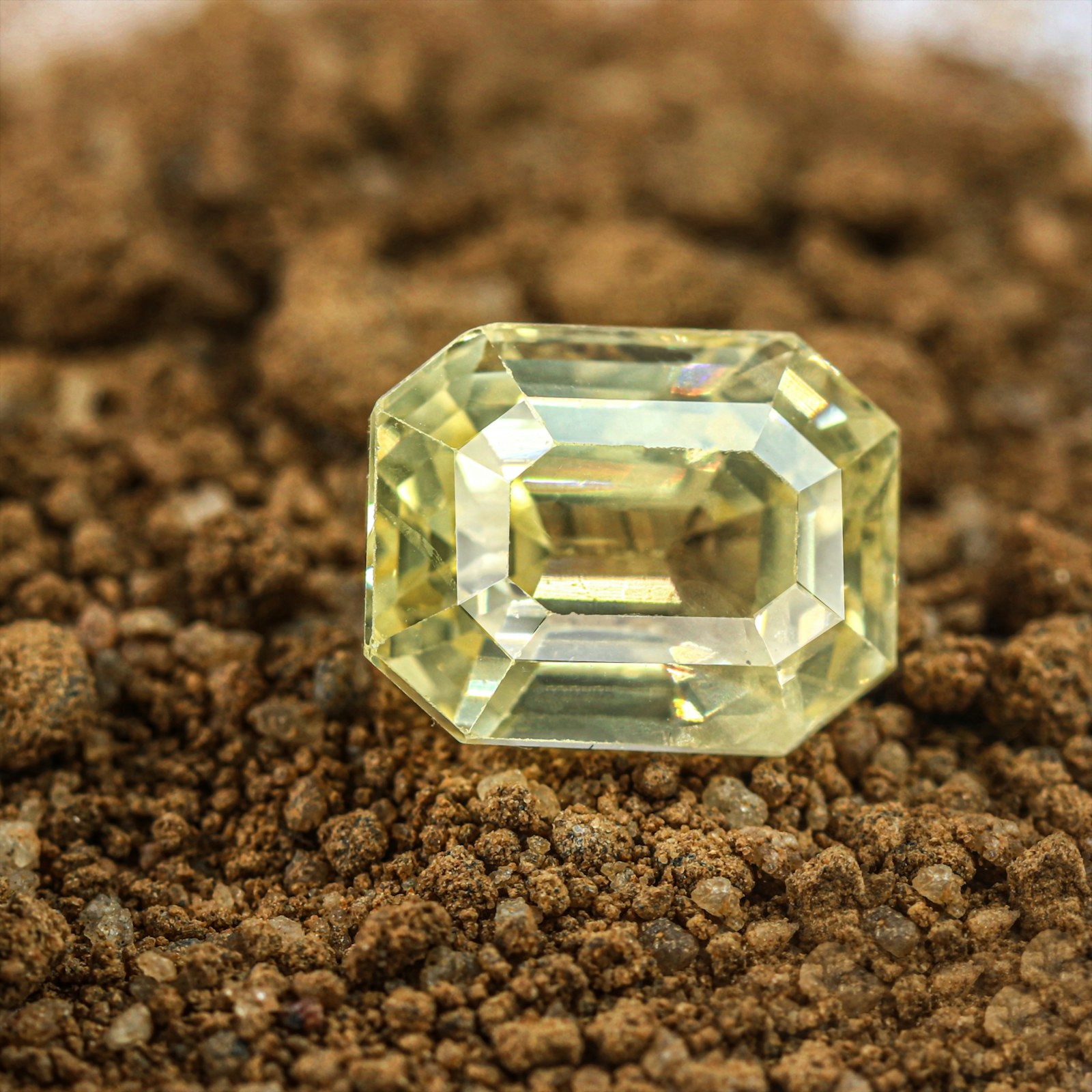 A pale yellow emerald-cut gem with a bright window through the center.
