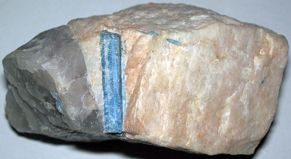 A blue aquamarine crystal still inside a pale rock.