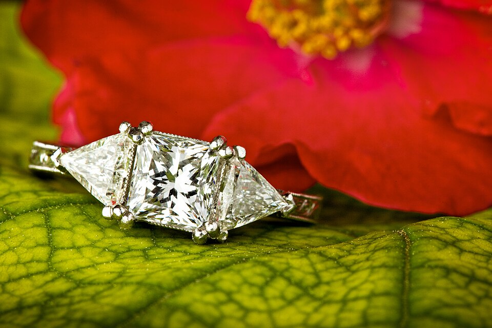 A ring with a square center diamond and two triangular side diamonds.