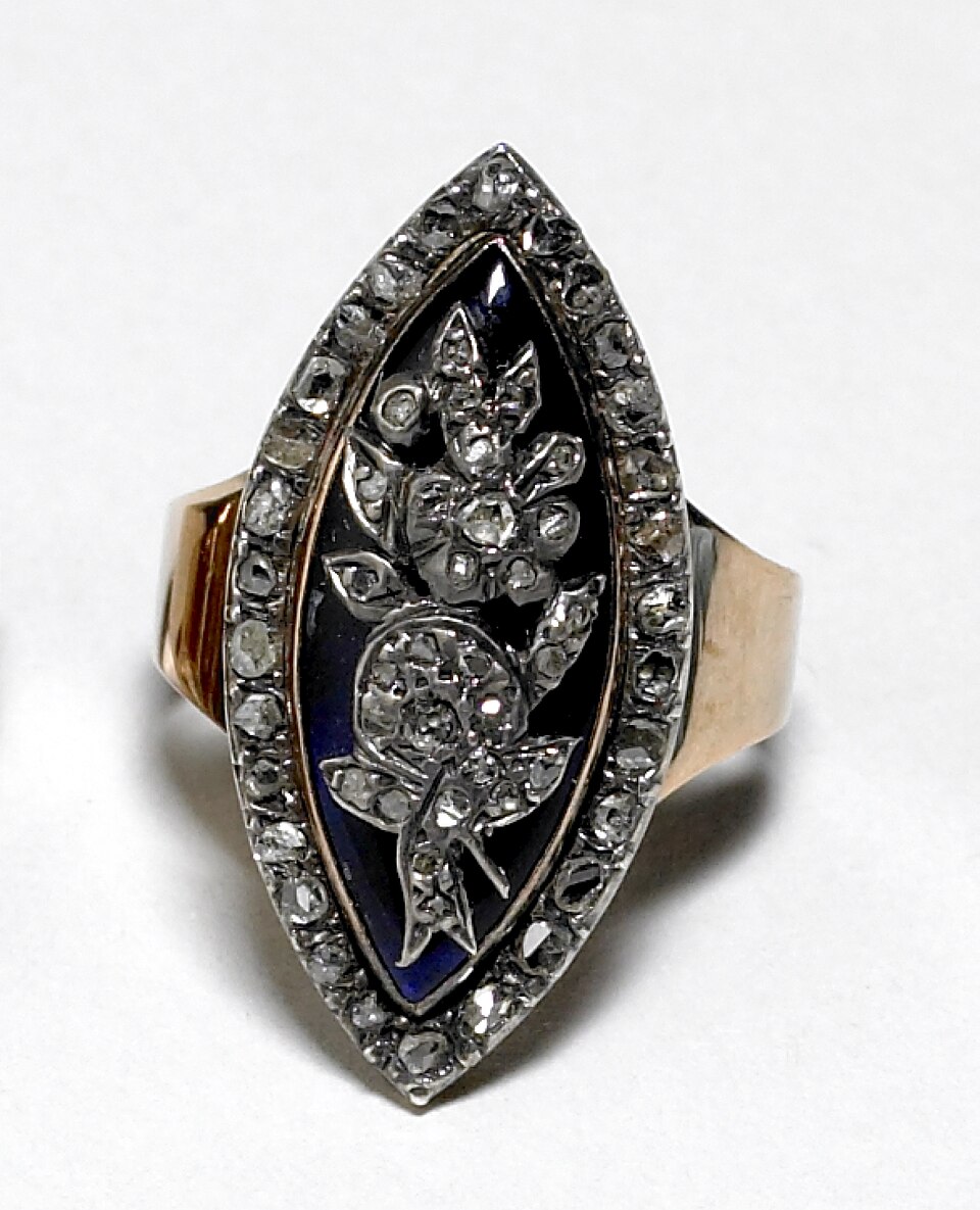 A navette-shaped ring set with many small diamonds around a blue enamel flower.