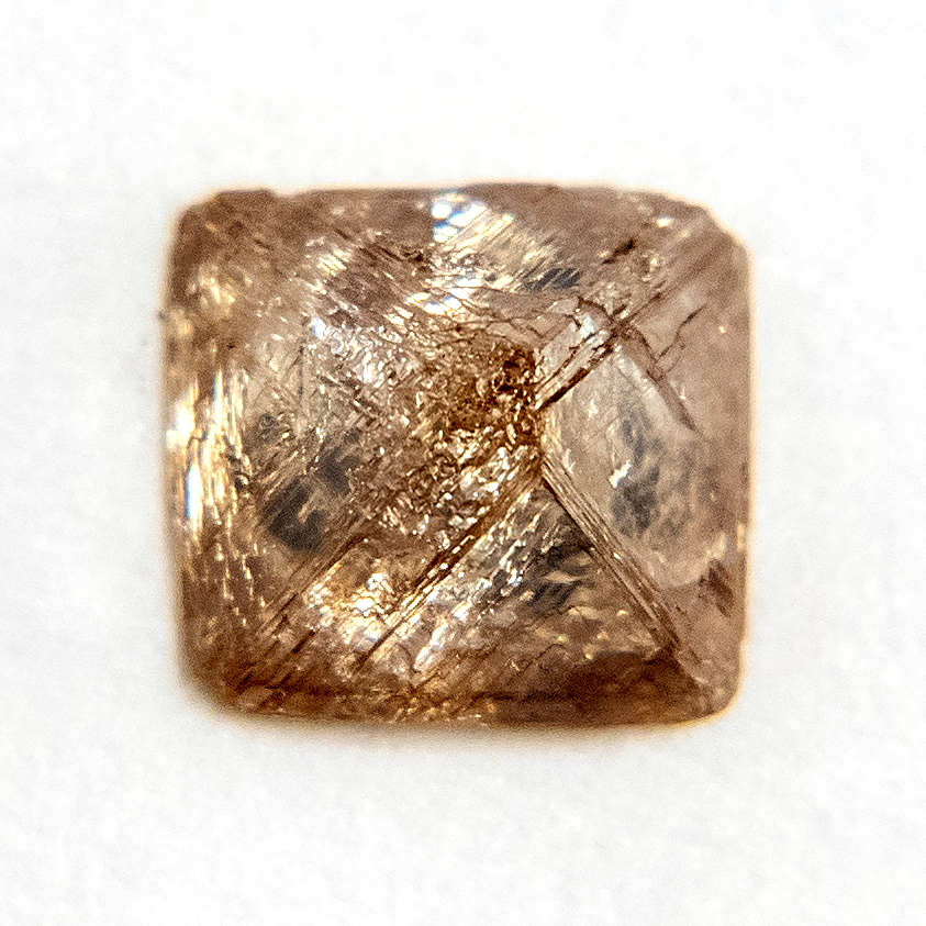 A light brown diamond crystal sawn open to show the inside.