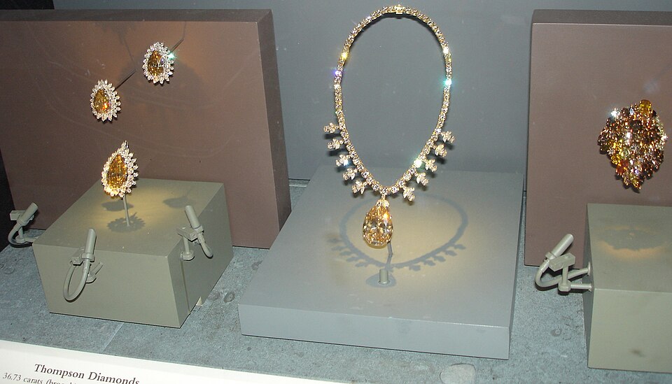 Golden-brown diamond jewelry in a museum case.