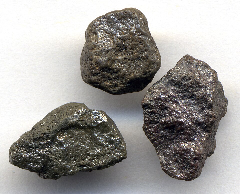 Three dark polycrystalline diamond lumps.