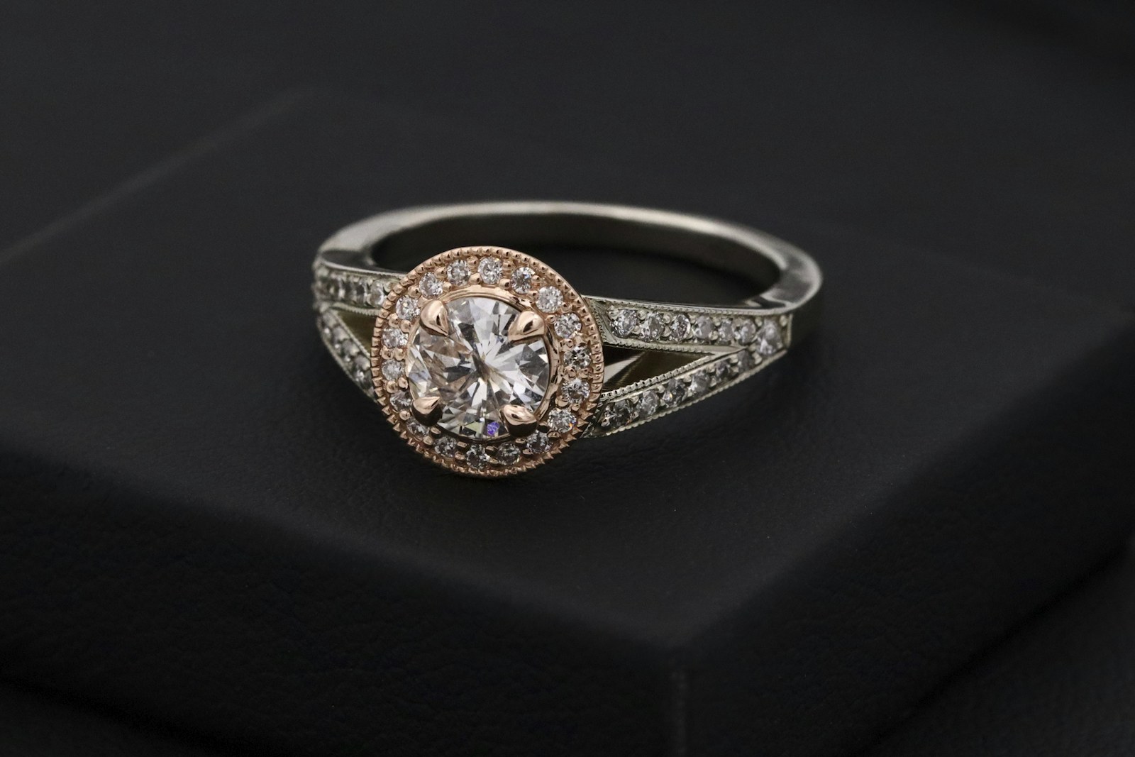 A halo diamond ring with a round brilliant center.