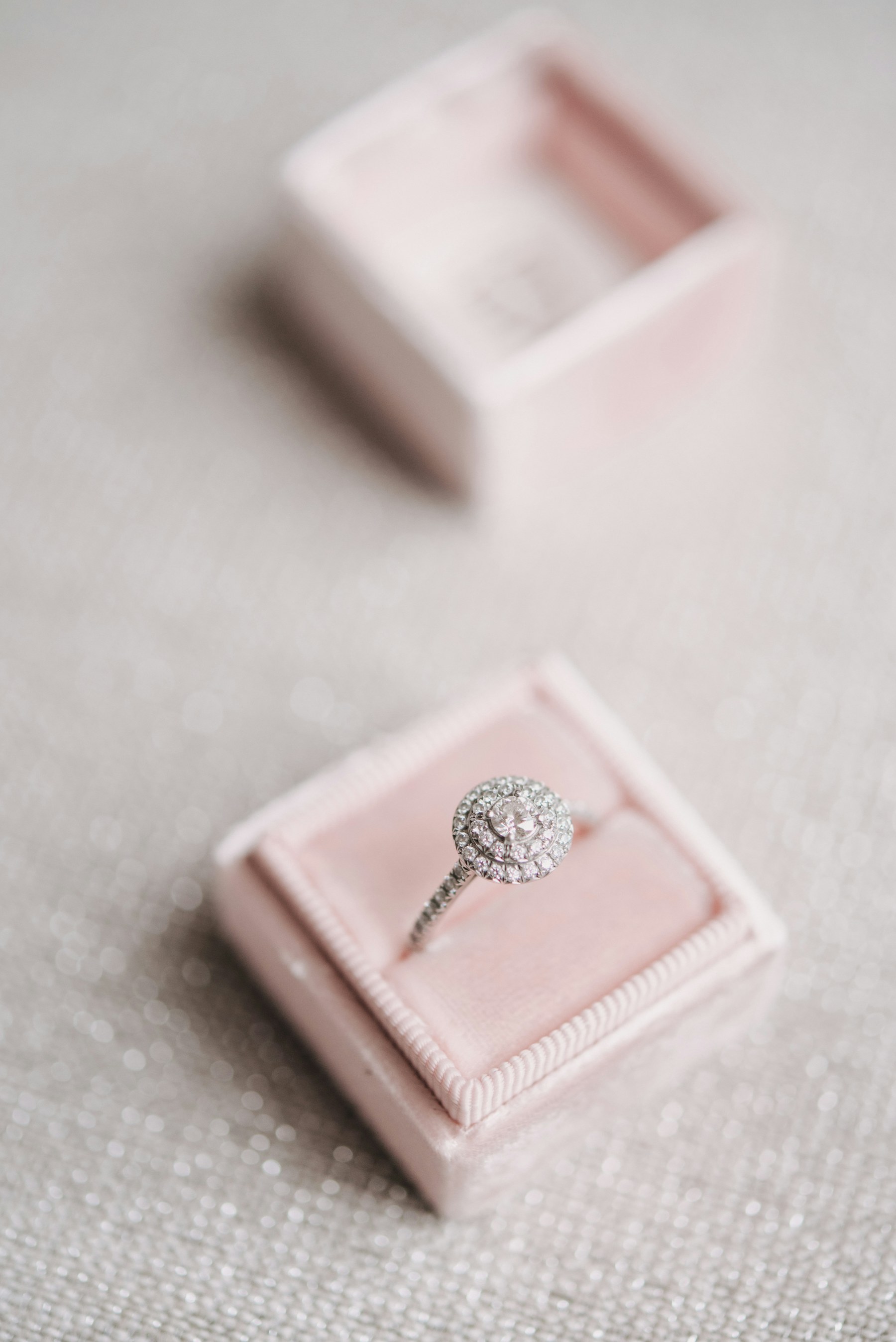 A diamond ring in an open pink box.